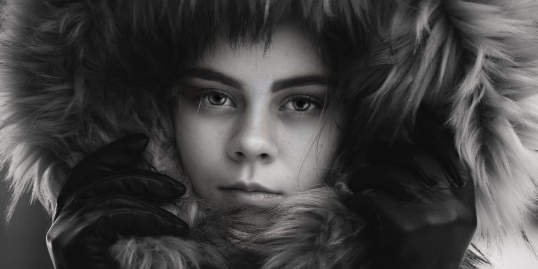 A black-and-white portrait framed by a winter hood.